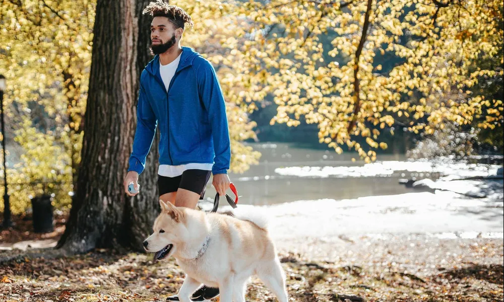 man with dog by water