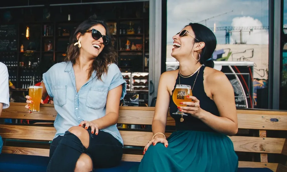 Two girls enjoying a beer outdoors
