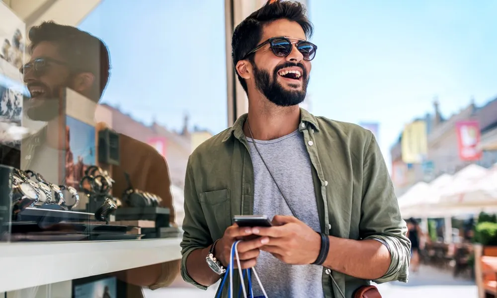 man smiling and shopping outdoors
