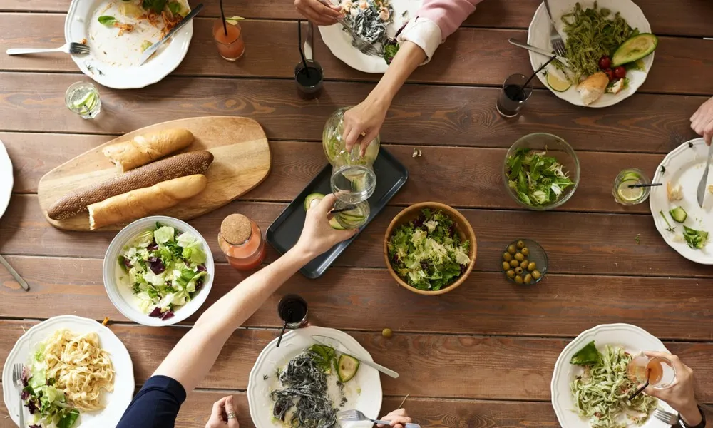 birds eye view of people toasting drinks over dinner table