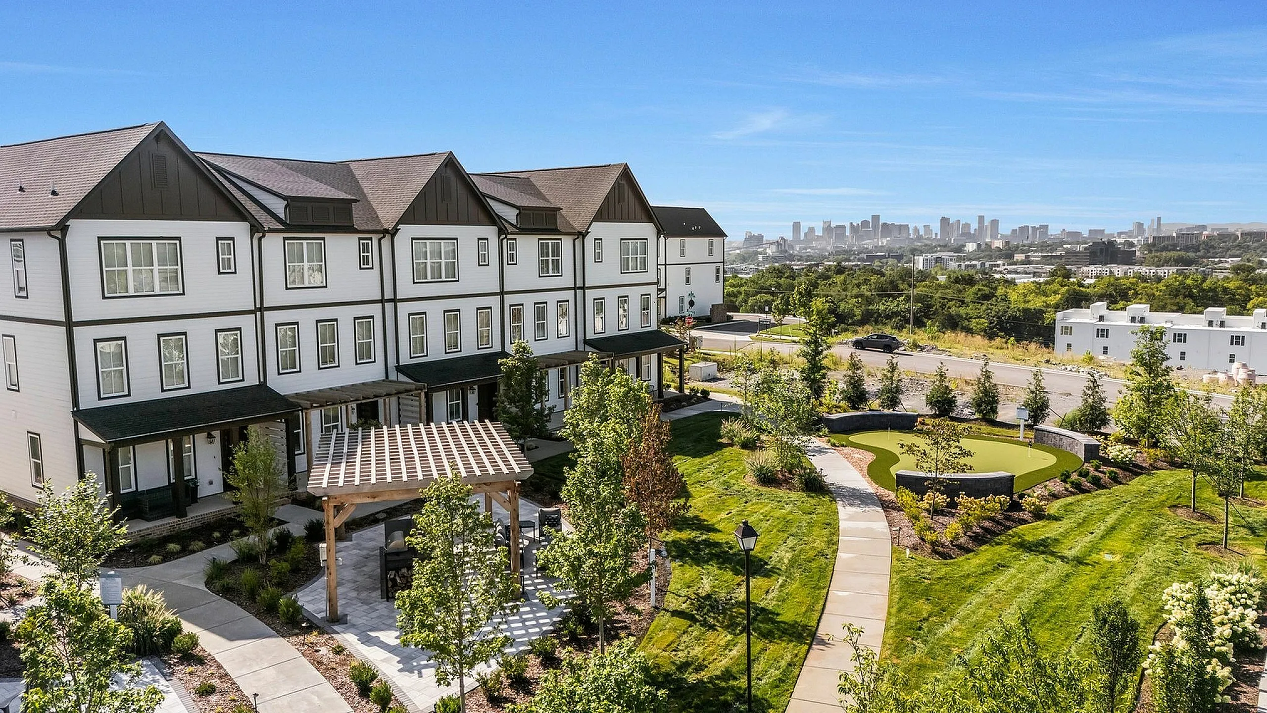 Charming townhouse complex with lush landscaping, pergola.