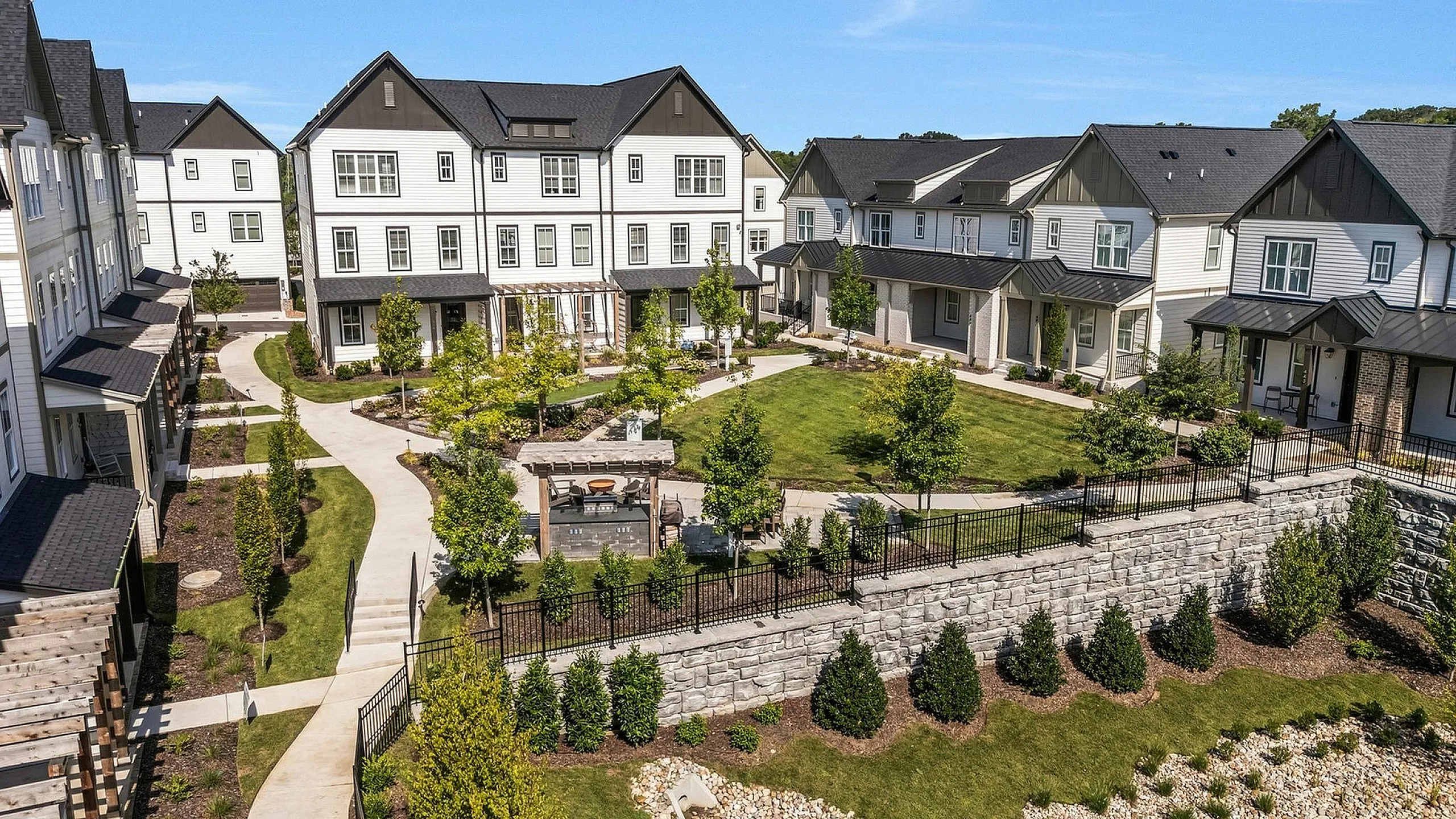 Charming townhouse community with modern architecture, lush green lawns, and inviting pathways for a serene neighborhood experience.