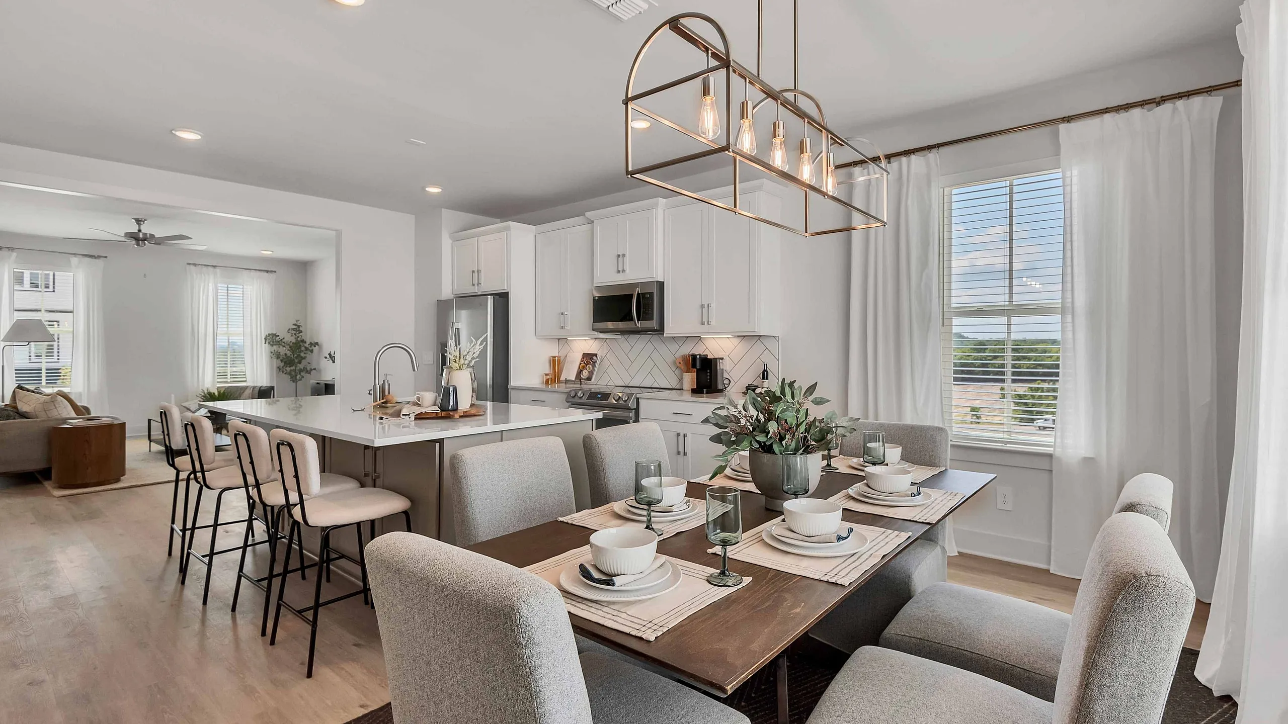 upscale decorated dining and kitchen areas with white cabinets and upgraded lighting