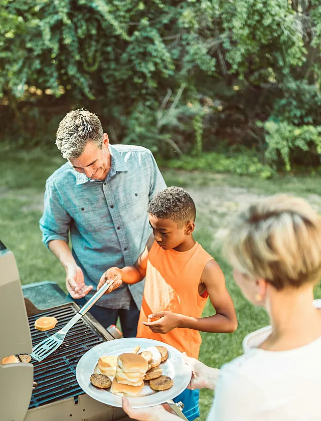 man showing kid how to grill