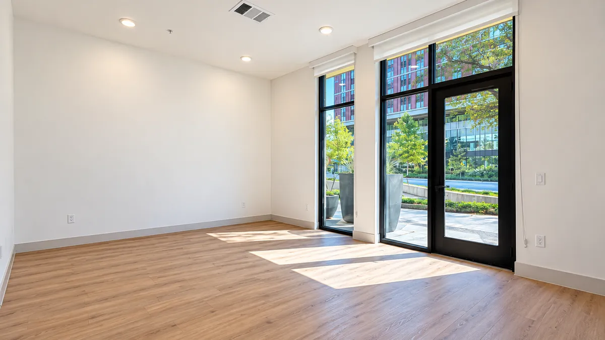 Concept image of an empty Live/Work space with wood floors and floor-to-ceiling windows