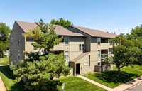 Charming apartment building with lush greenery and a serene suburban vibe; perfect for modern living.