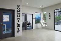 Lounge with private offices, a hanging bubble chair, abstract art, and large windows with a view of the courtyard