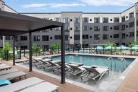 Modern apartment complex with a stunning outdoor pool and sun loungers, perfect for relaxation and leisure.