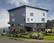 Exterior of Foundry Flats, Emmaus, PA featuring modern design, gray and white siding, large windows, and landscaped grounds.