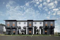Front view of Foundry Flats, Emmaus, PA with modern gray and white facade, private balconies, and landscaped exterior.