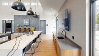 Modern and inviting community space at Foundry Flats Apartments with sleek lighting, a stylish bar area, and contemporary design elements.