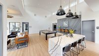 Modern communal space in Foundry Flats Apartments featuring a sleek pool table, stylish seating area, and chic pendant lighting, perfect for socializing and relaxation.