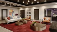 Stylish lobby area with modern decor, featuring a plush sofa, elegant seating, and chic coffee tables on a vibrant red carpet.