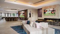 Modern lounge area with sleek bar seating, cozy fireplace, and large screen TV, ideal for social gatherings.