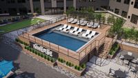 Luxurious rooftop pool area with sleek loungers and a modern pergola, offering a stylish outdoor retreat.