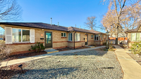 Charming single-story brick apartment with large windows, nestled in a serene, landscaped community.