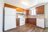Charming kitchen with warm wooden cabinets, modern appliances, and elegant tile backsplash, offering a perfect blend of style and functionality.