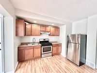 Modern kitchen featuring sleek stainless steel appliances, warm wooden cabinetry, and elegant hardwood flooring.