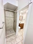 Chic bathroom showcasing a modern walk-in shower with elegant tile work and a sleek vanity.