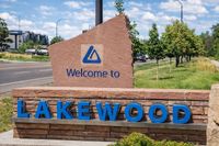 Inviting welcome sign for Lakewood, framed by lush greenery and a clear blue sky, creating an appealing entrance to the area.