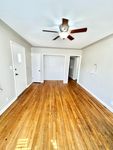 Bright and inviting living space featuring polished hardwood floors and a stylish ceiling fan, perfect for any modern home.