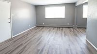 Bright and spacious living area with sleek gray flooring and modern neutral walls, perfect for stylish urban living.