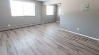 Modern apartment interior with sleek gray walls, expansive windows, and elegant hardwood flooring, perfect for a cozy and inviting atmosphere.