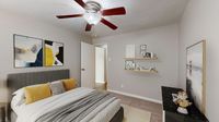 Inviting bedroom with contemporary decor, featuring a stylish queen bed with yellow accents, modern ceiling fan, and elegant artwork on the walls.