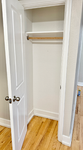 Spacious closet with classic white doors and elegant hardwood flooring, ideal for ample storage.