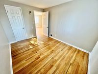 Bright and welcoming room with elegant wooden floors, large doors, and ample natural light.