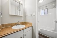 Bathroom featuring a modern sink, elegant mirror, and ample natural light