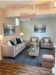 Inviting living room with elegant furniture, artful decor, and a cozy ambience offering 1 month free rent.