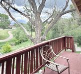 Charming balcony view with a tranquil backdrop of lush greenery and a scenic pathway, perfect for relaxation.