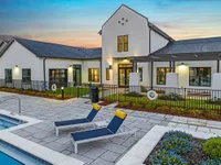 View of exterior of leasing office with pool and pool chairs in foreground