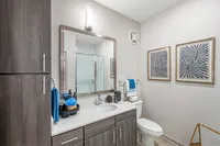 Furnished bathroom with large vanity and linen shelving