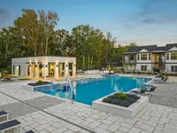 Outdoor pool with covered patio and view of exterior of community