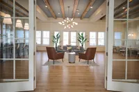 Stylish open lounge with elegant seating, modern lighting, and large windows.