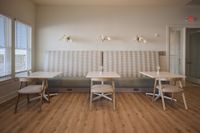 Stylish dining area with modern seating, wooden floors, and ambient lighting.