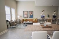 Stylish living room with modern furniture, featuring artwork of dogs in suits and a cozy workspace.