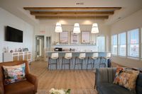 Modern lounge area with stylish seating, a sleek bar counter, and decorative ceiling beams.