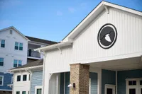 Elegant exterior of modern apartment complex with blue and white siding, showcasing architectural design and a serene atmosphere.