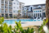Stunning apartment complex with a sparkling pool and lush landscaping.