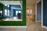 Bright gym with modern equipment and welcoming living room in elegant apartment complex.