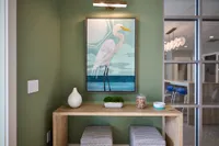Charming corner nook with a stylish bird painting, modern wooden table, and cozy seating.