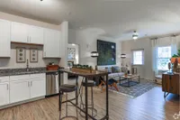 Inviting open-concept kitchen and living room with contemporary decor and natural light.