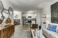 Modern open-plan living space with chic decor, featuring a stylish kitchen, cozy seating area, and elegant furnishings.