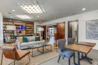 Stylish apartment lounge with modern furniture, wooden accents, and artistic decor.