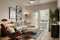 Stylish living room with contemporary decor, large sofa, art pieces, and a view of the balcony.