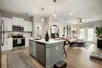 Modern open-concept kitchen with a stylish island and a cozy living area with natural light and elegant decor.