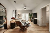 Chic living room with modern furniture, wooden flooring, large TV, and decor accents.